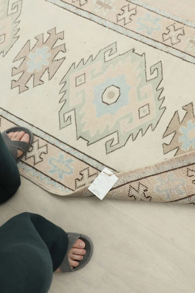 Person's feet next to the rug, indicating scale and showing the rug's tag