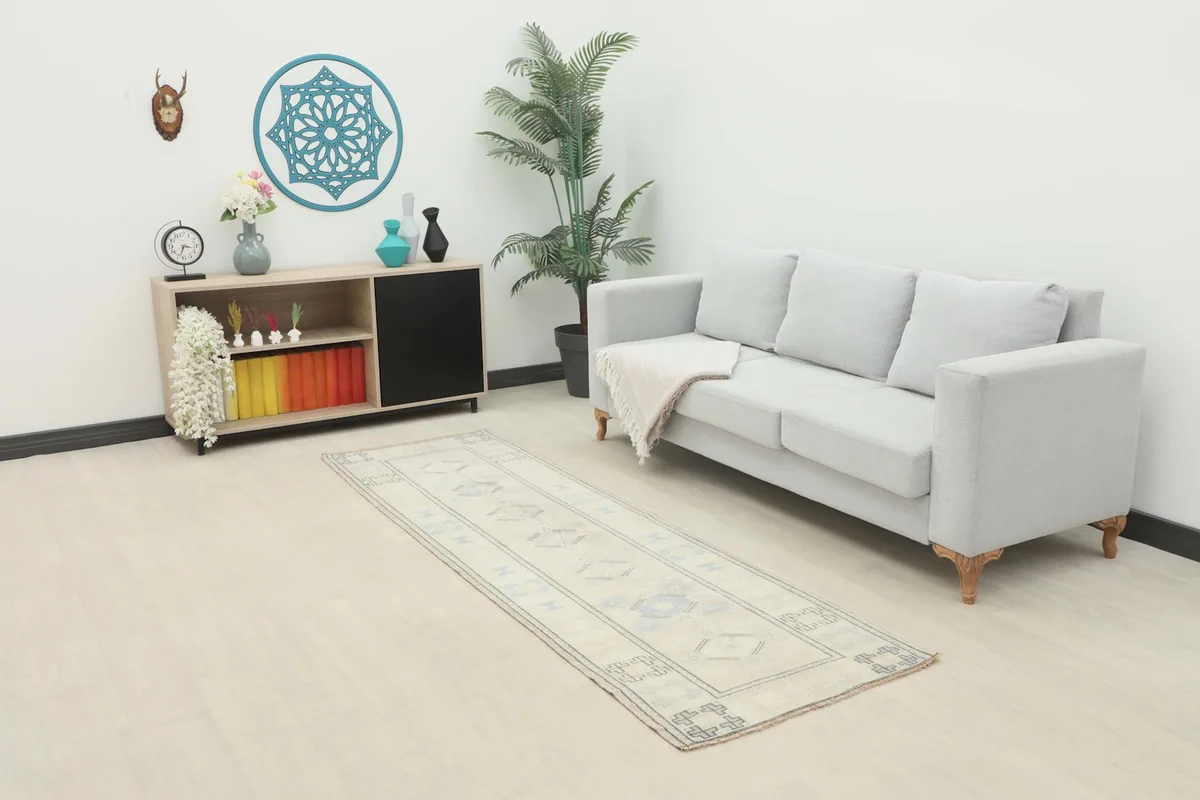 Ivory and blue runner rug placed in a modern living room setting with a light gray sofa