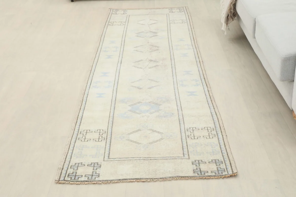 Full view of the ivory and blue runner rug laid out in a room, offering a sense of scale