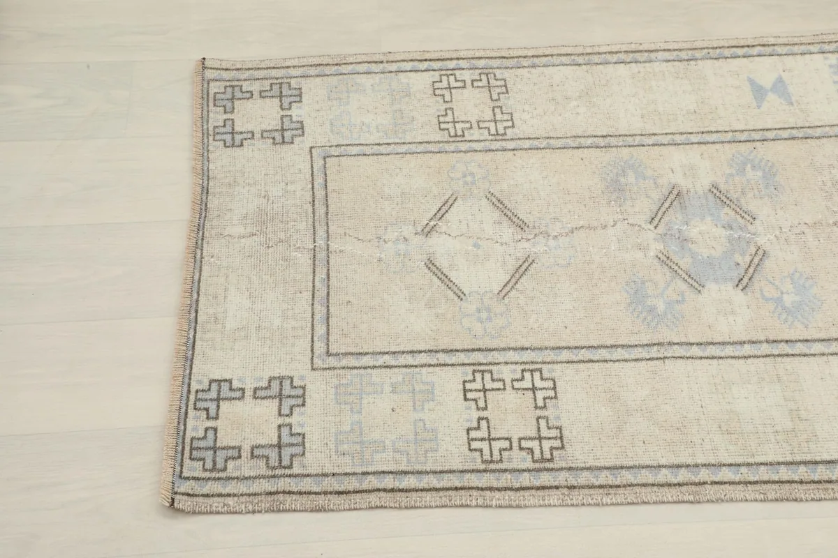 Close-up of the rug's opposite end, showing the subtle color variations and worn patterns