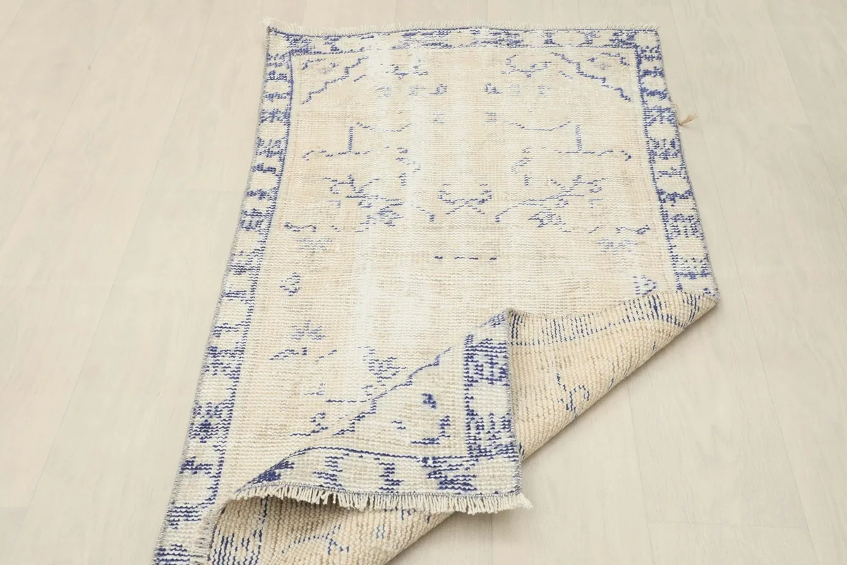 Overhead view of the rug with a corner folded back, displaying both front and back textures.