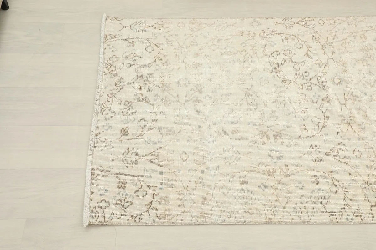 Close-up of the rug's corner, highlighting the intricate cream and beige design
