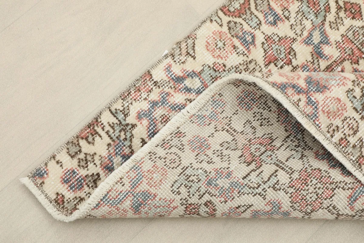 Corner of the rug folded back to show the cotton foundation and the reverse side of the hand-knotted construction