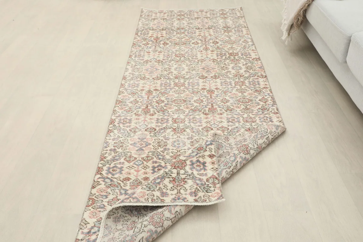 Rug with a corner folded back, illustrating its flexibility and construction from a room perspective