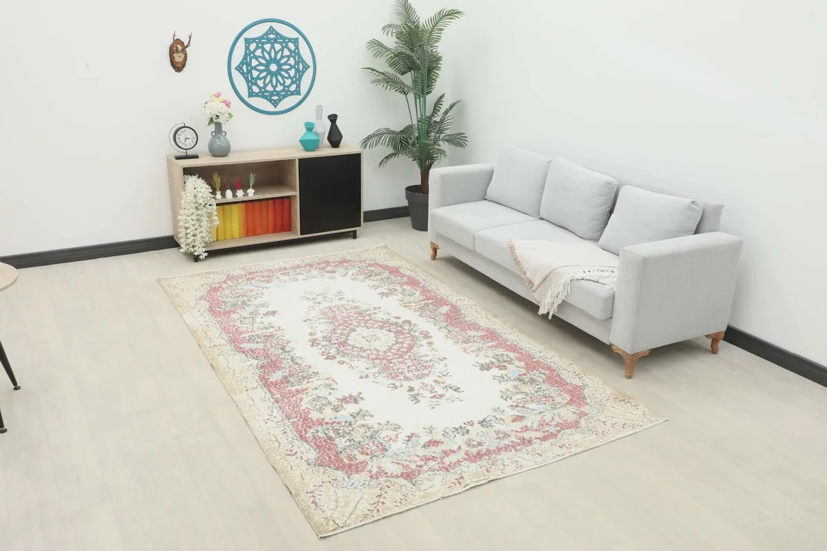 Vintage Anatolian rug placed in a living room setting with a light gray sofa and wooden furniture.
