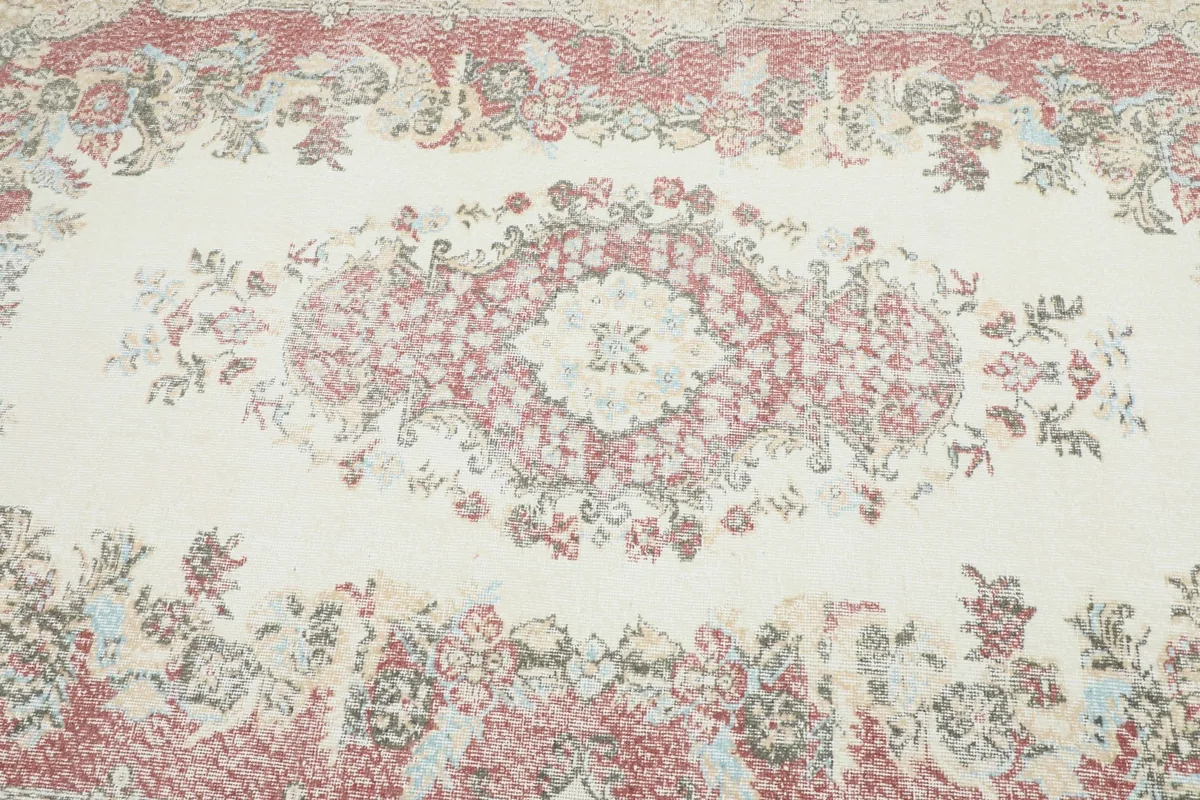 Detailed view of the central rose medallion and surrounding floral motifs on the cream background.