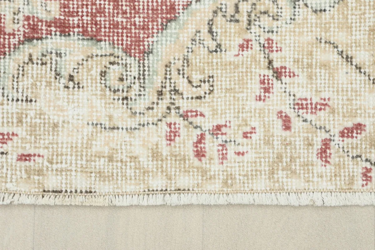Close-up of the rug's edge and fringe, revealing the cotton foundation and hand-knotted construction.