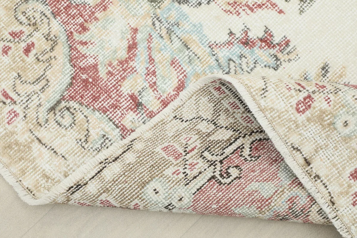 Folded corner of the rug, showing the reverse side and the density of the hand-knotted wool.