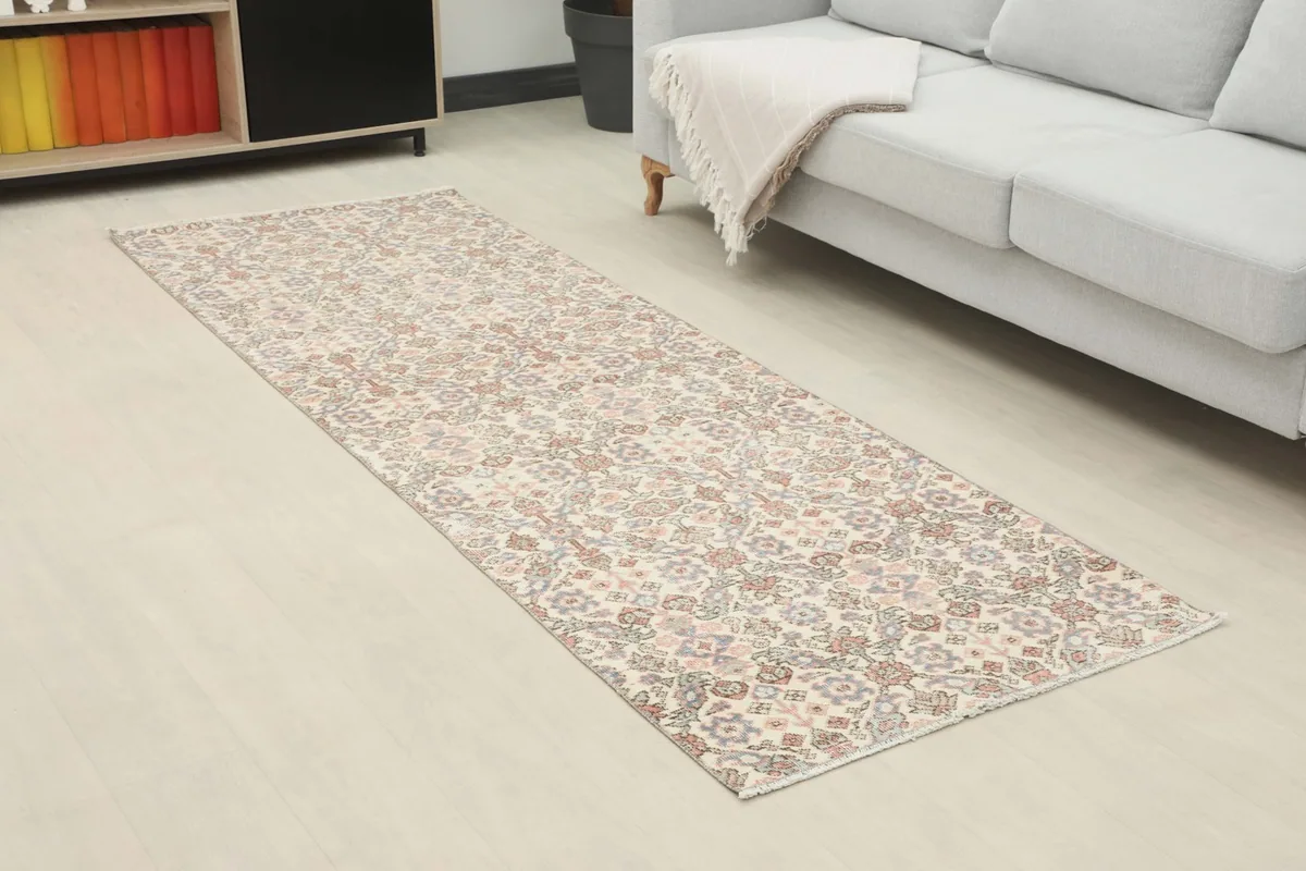 Angled view of the runner rug extending across a room with light flooring.