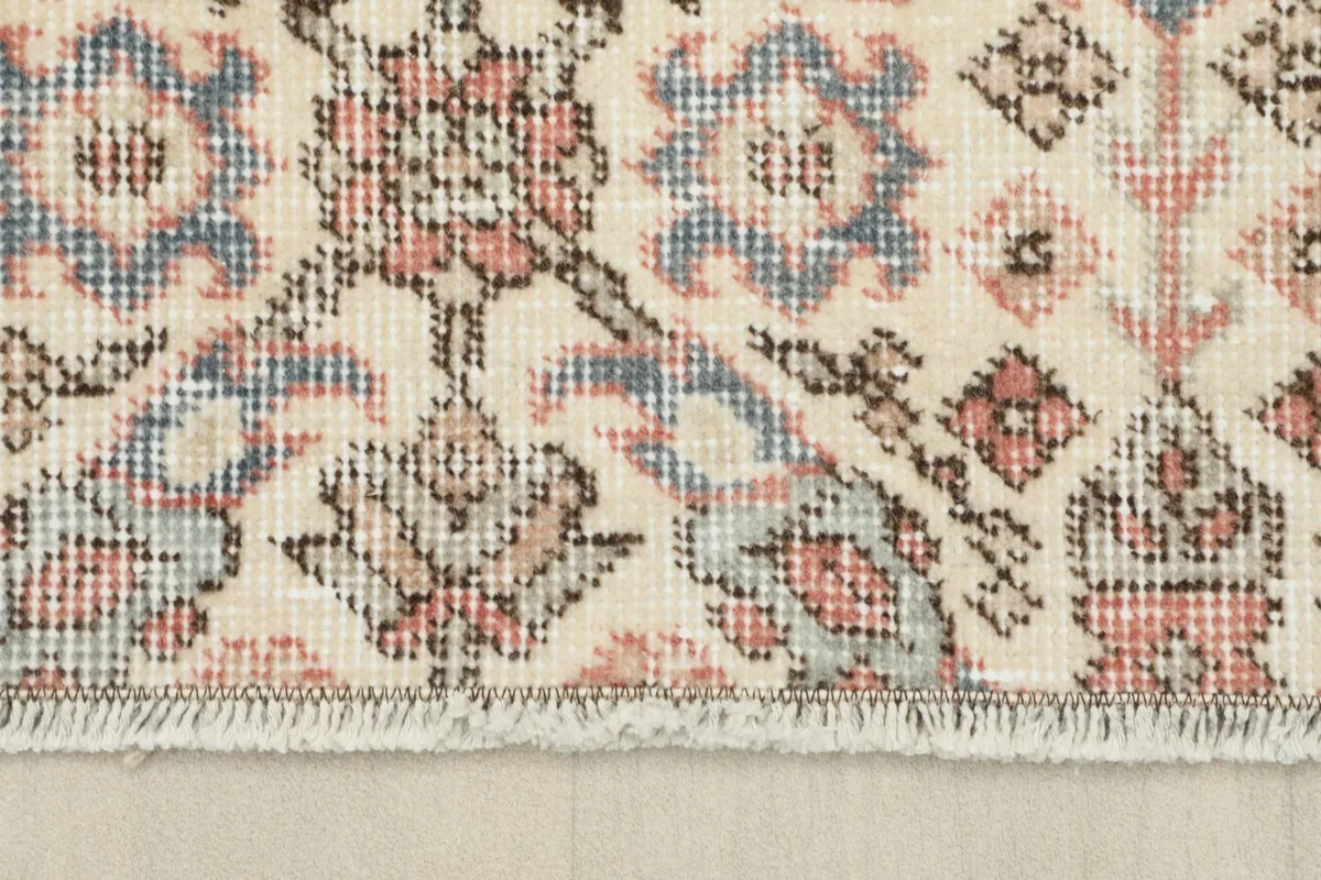 Close-up of the short, natural fringes and edge of the vintage runner rug.