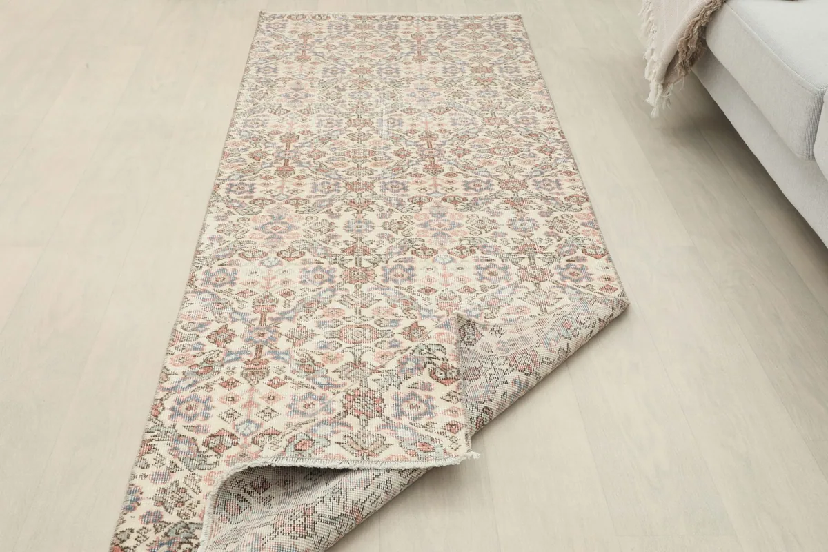 Runner rug displayed with one end folded over, showing the thickness and flexibility.