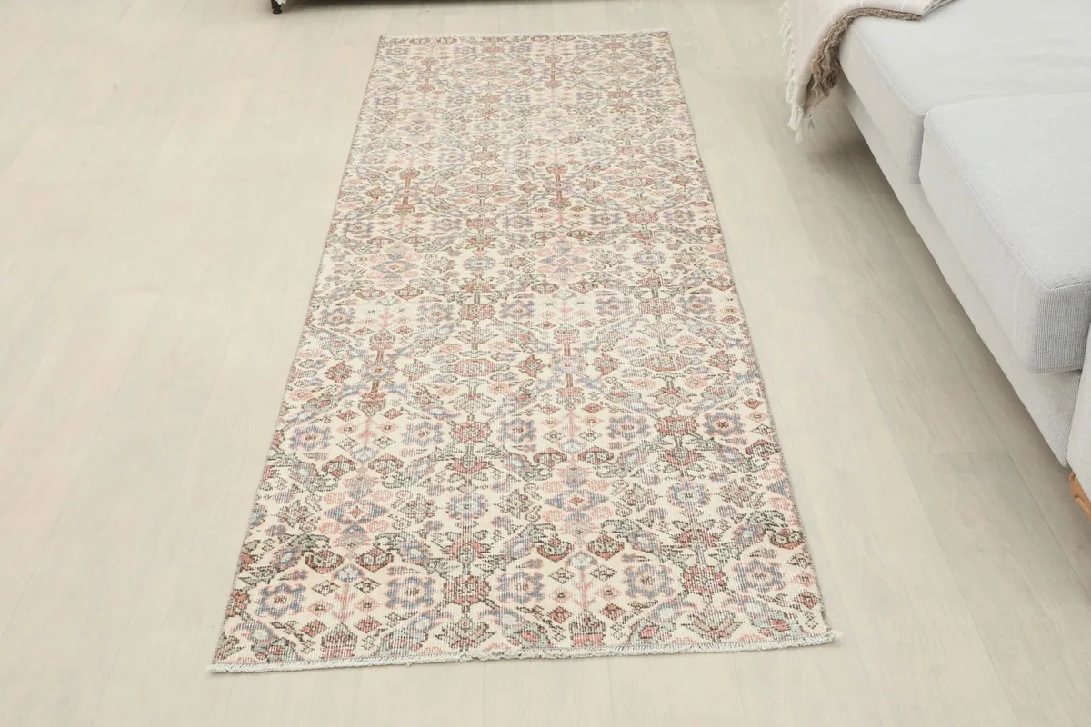 Full overhead view of the runner rug in a room setting, next to a light gray couch.