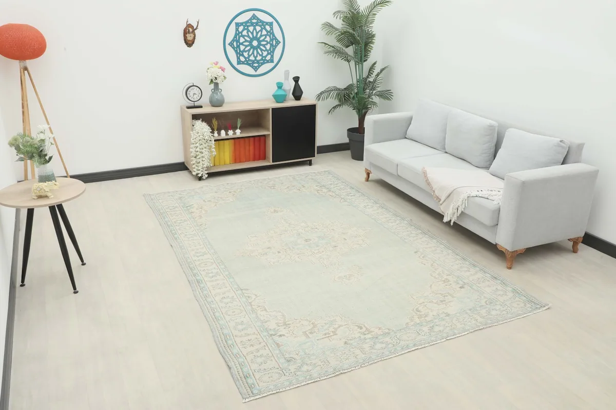 Vintage blue and ivory area rug placed in a living room setting with a light sofa and minimalist decor