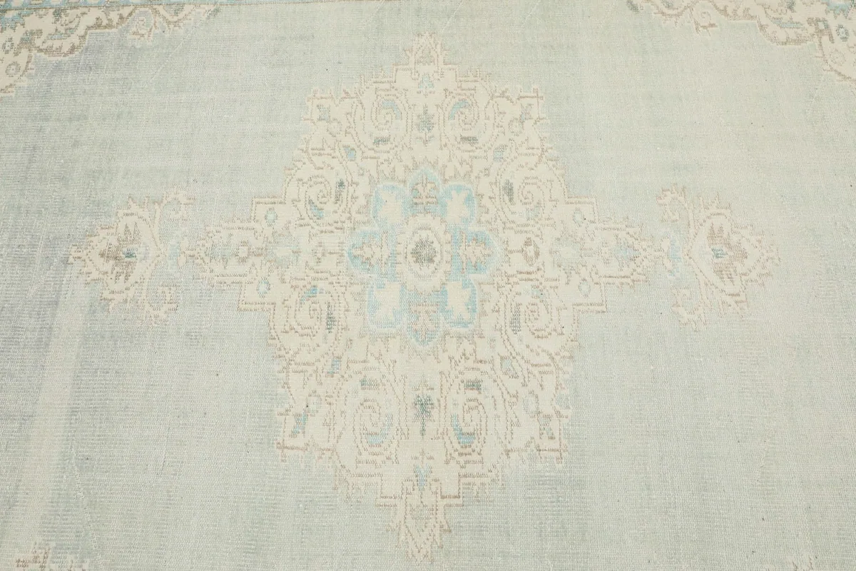 Close-up detail of the central medallion motif, showcasing the intricate blue and ivory weaving
