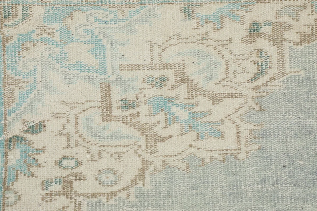 Detailed view of the rug's surface, showing the subtle wear and hand-knotted texture