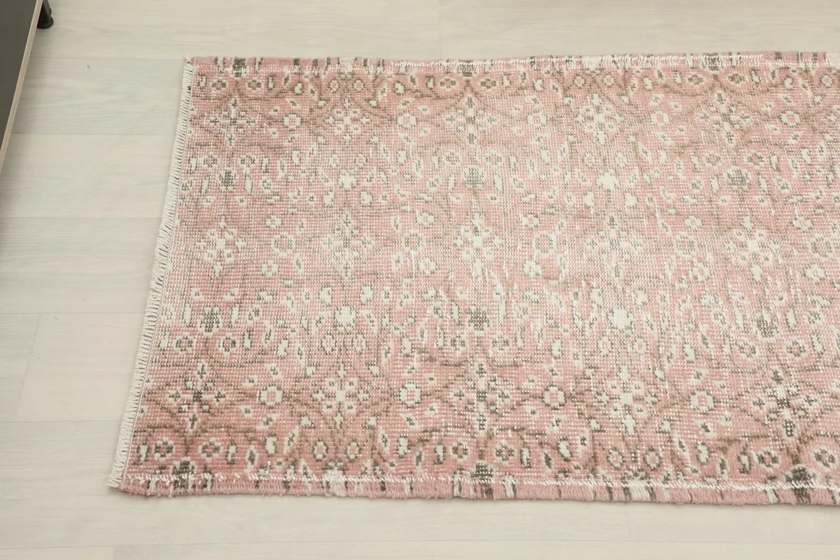Detailed view of the runner's pattern, highlighting the faded rose and ivory wool pile