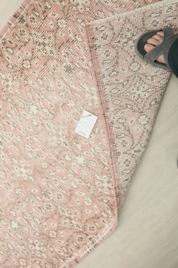 Foot next to the rug showing scale and the texture of the wool pile and foundation