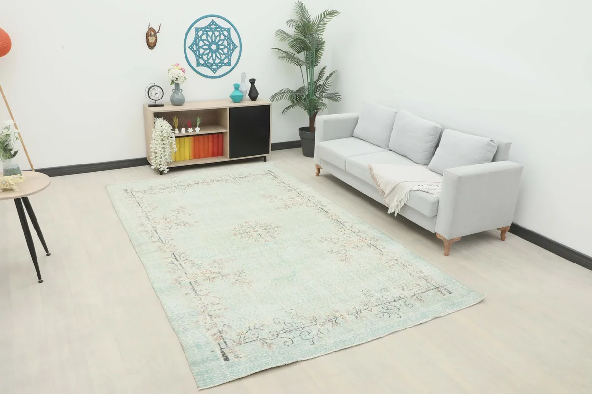 Vintage Anatolian rug displayed in a living room setting with a sofa and side table.