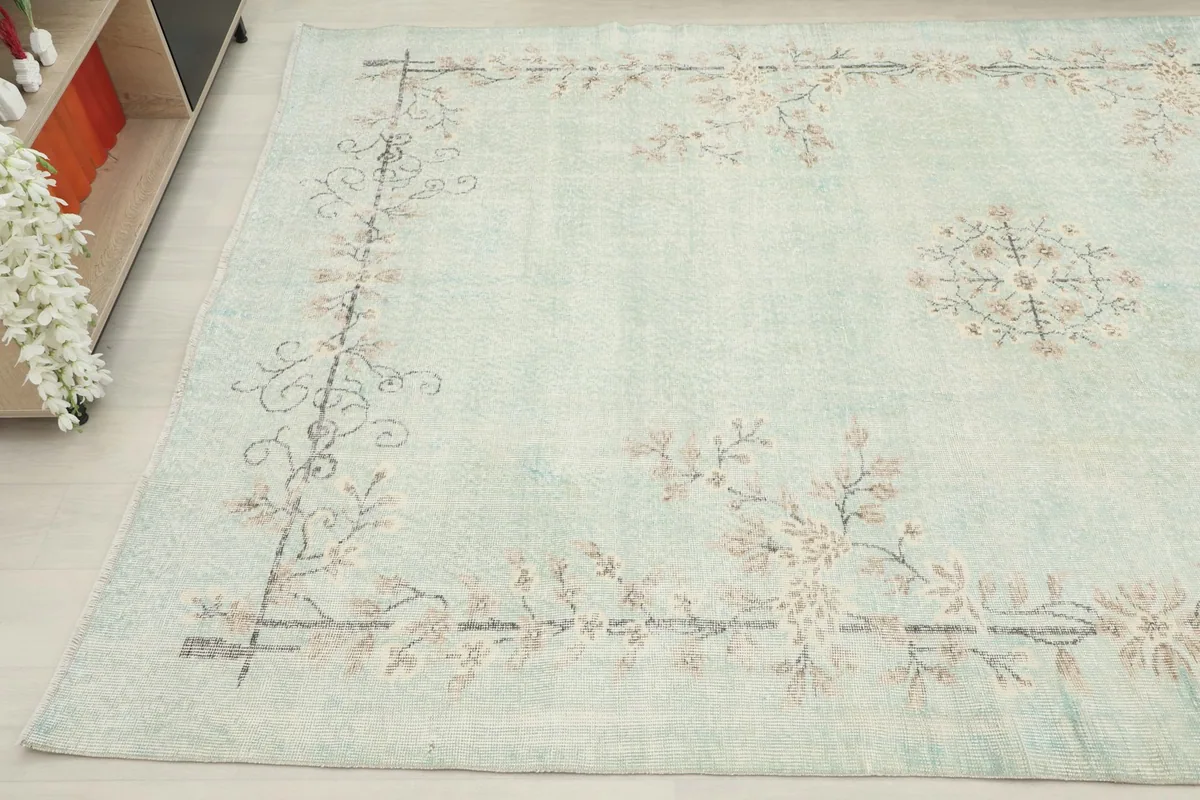 Detailed view of another corner of the rug, showcasing the beige and brown floral motifs.