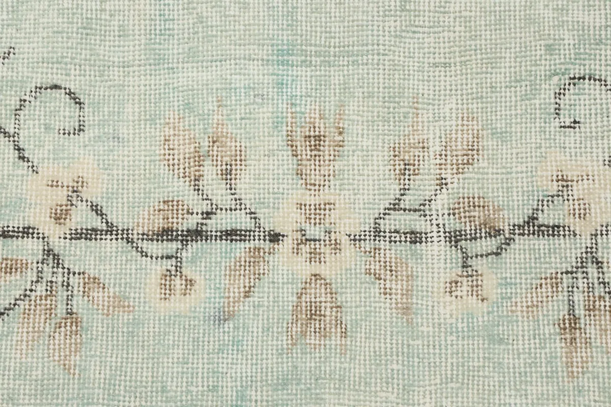 Close-up of the intricate floral and vine patterns along the rug's border.