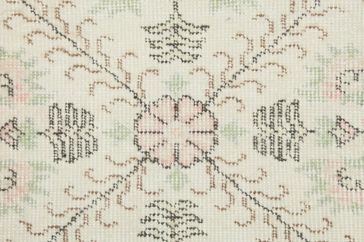 Detailed close-up of the rug's wool pile, showing individual floral and geometric knotwork