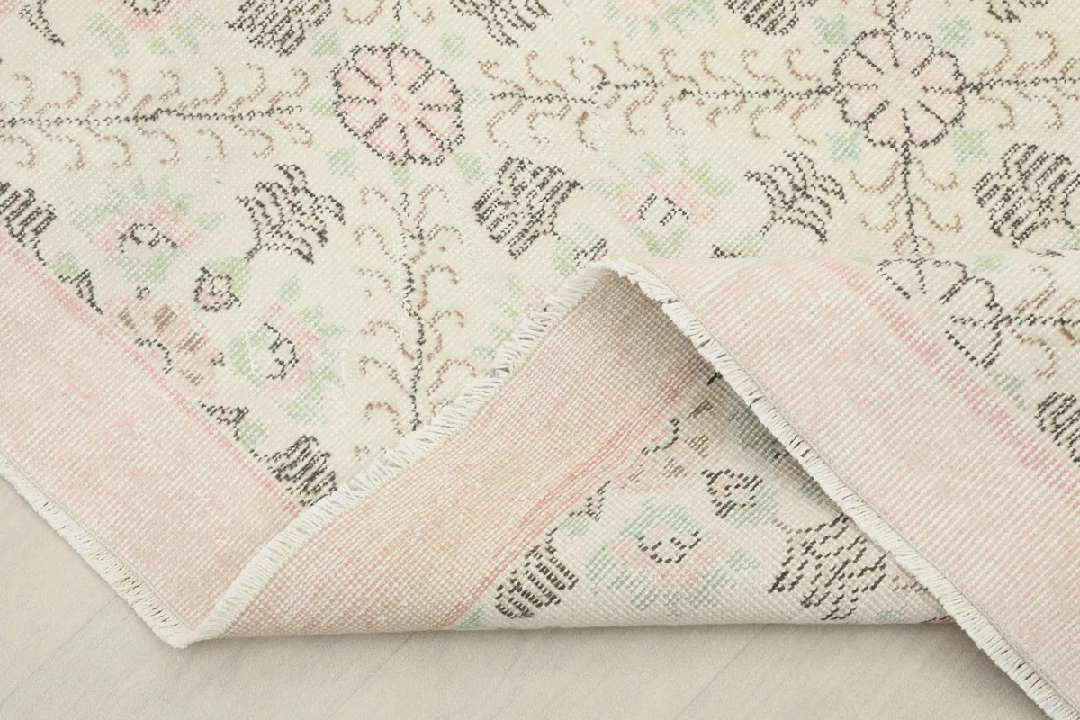 Folded corner of the rug, illustrating the wool pile on cotton foundation and the reverse side