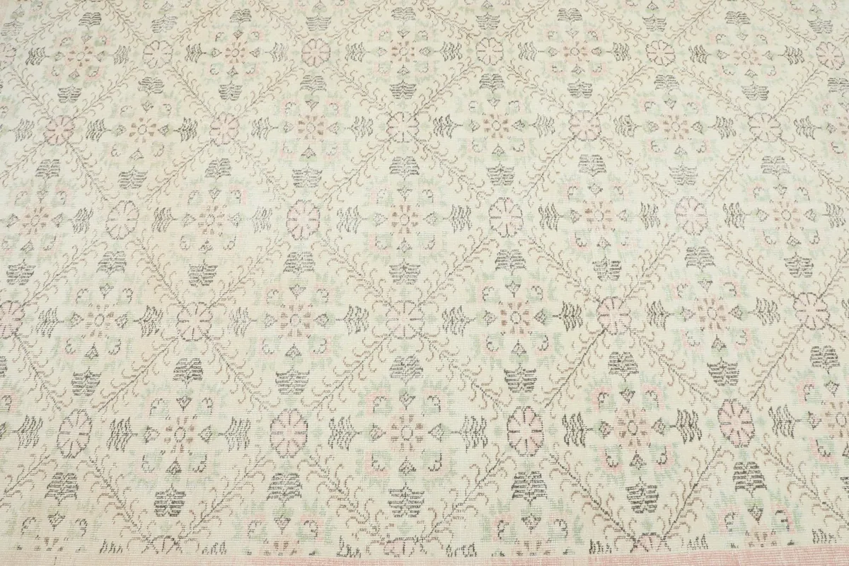 Close overhead view of the rug's field, revealing the intricate floral and geometric motifs in gray and green
