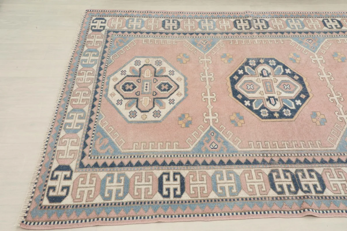 Another angled view of the rug, showing the full width of the rose field and the detailed geometric border.