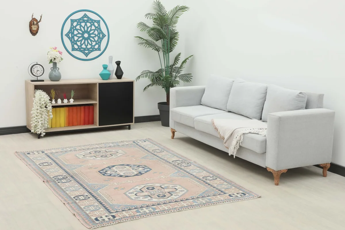 Vintage rose and navy geometric rug displayed in a modern living room setting with a light gray sofa.