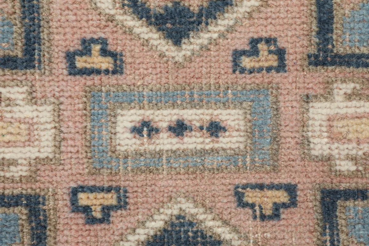 Extreme close-up view of the hand-knotted wool pile, showing individual knots and color variations.