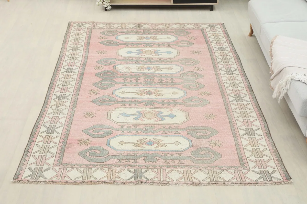Full view of the rose tribal rug in a room, offering perspective on its size and placement.