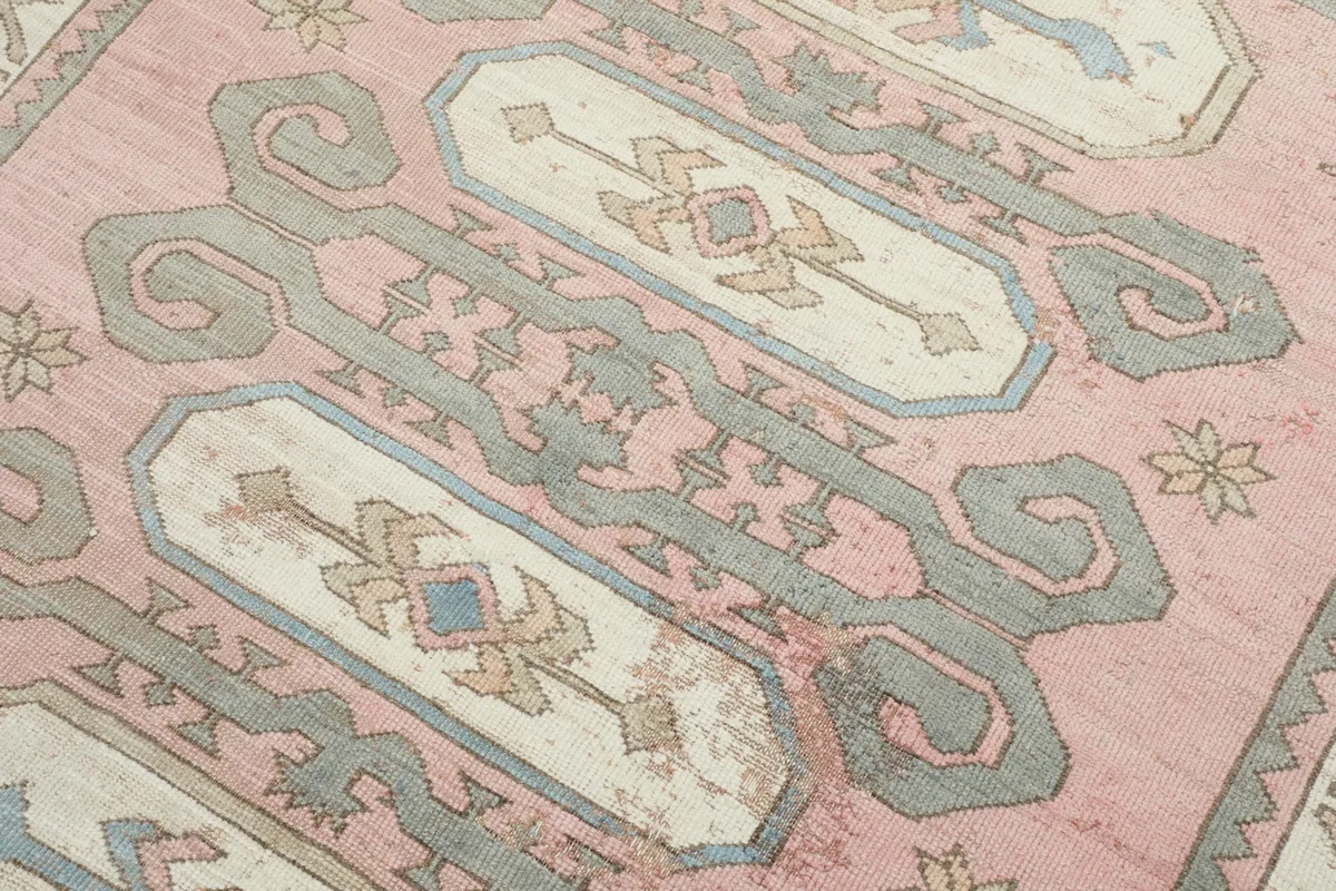 Detailed view of the central tribal medallion pattern with rose, gray, ivory, and blue colors.