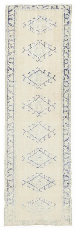 Full top view of the 2'8" x 10'6" ivory and blue geometric vintage runner rug on a white background.