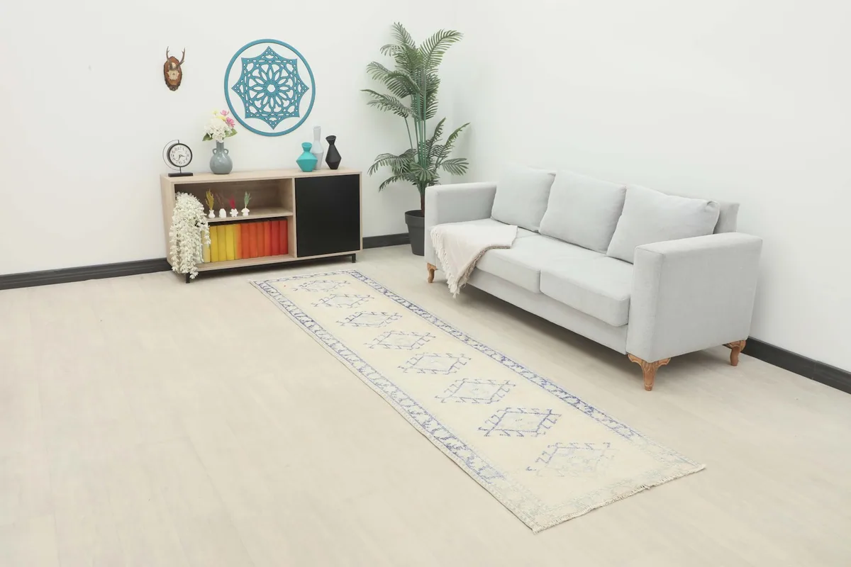Vintage ivory and blue runner rug in a modern living space with a light sofa and minimalist decor.