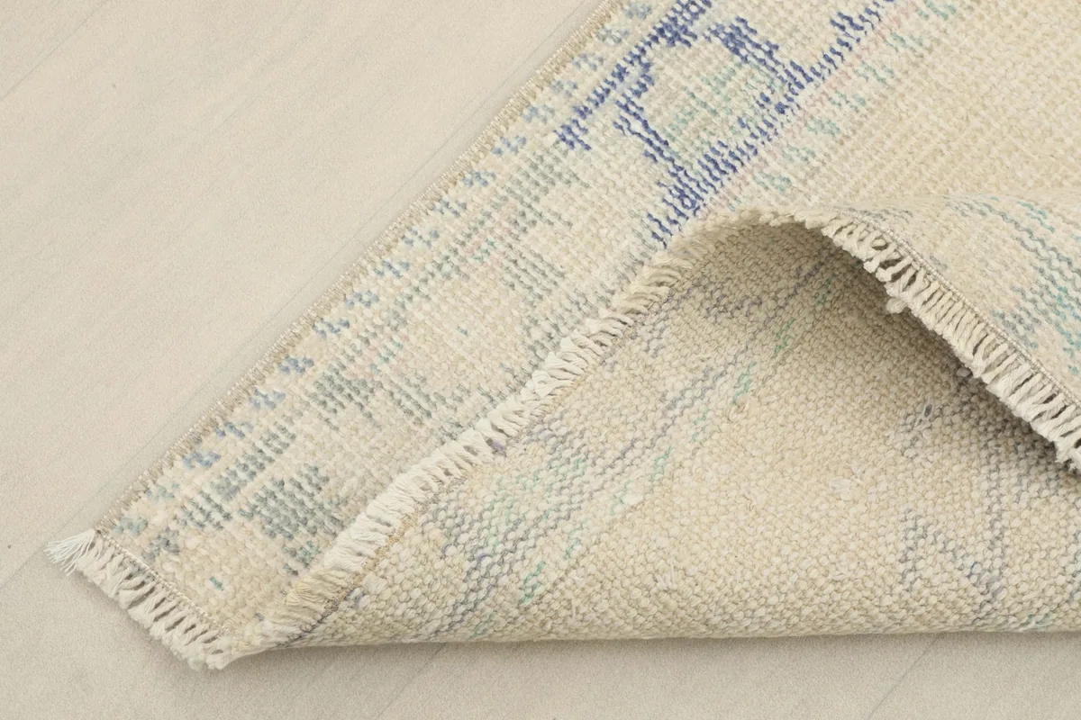 View of the back of the hand-knotted wool rug, showing the cotton foundation and fine knotting.