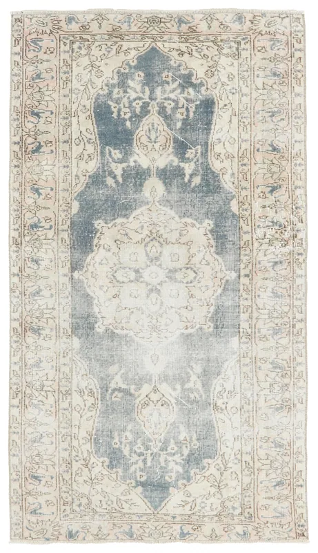 Full top view of the blue and ivory vintage Anatolian rug with a central medallion on a white background