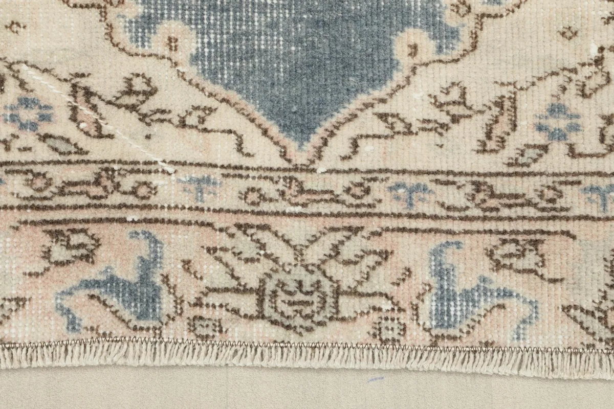 Detailed view of the rug's border showing its intricate patterns and the short, even fringe