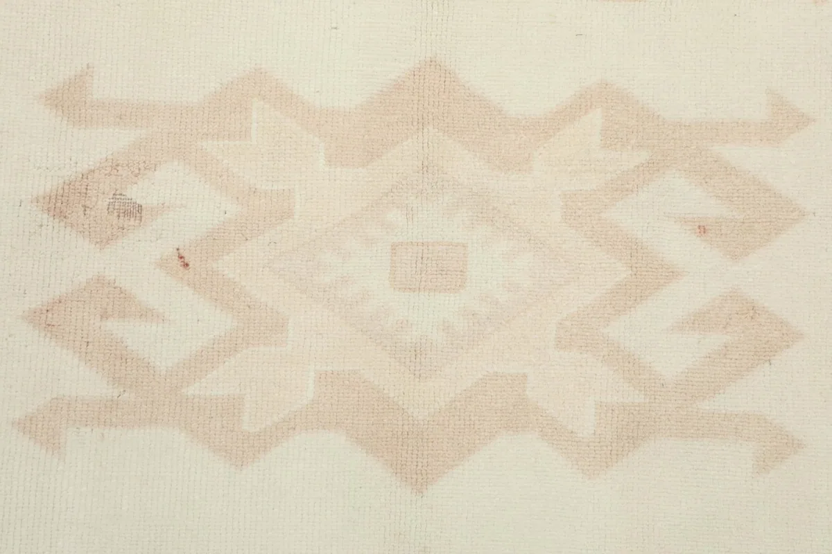 Extreme close-up of a central tribal motif, revealing the hand-knotted texture and color variations.