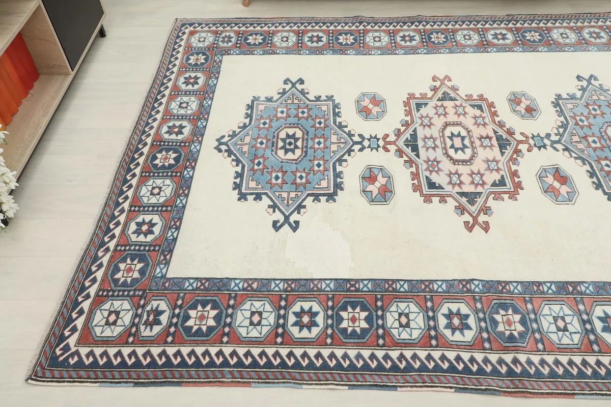 Another angled view of the rug's corner, showing the blend of ivory, blue, and rust colors