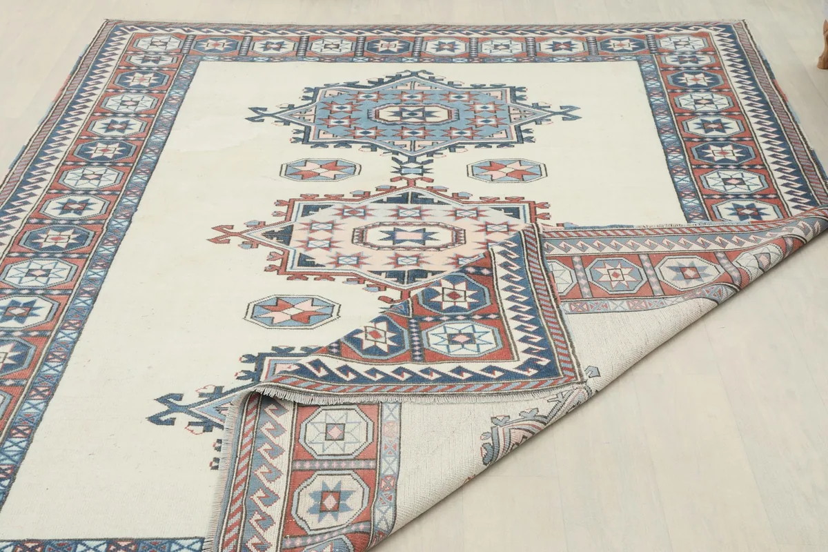 Partial view of the rug's reverse side and a corner folded back, showing the cotton foundation