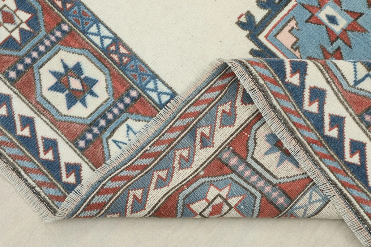 The rug folded to reveal the thickness of the hand-knotted wool pile and fringe