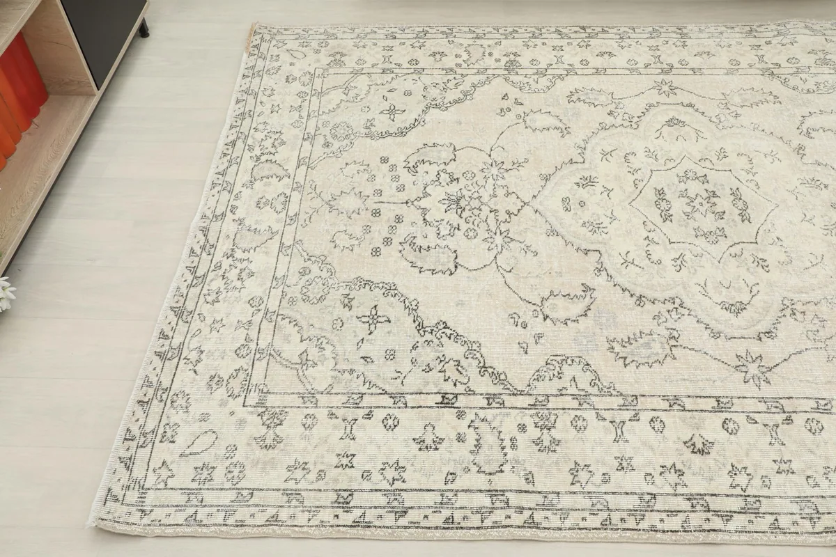Detailed view of the rug's patterns and colors from an angle, showing the subtle patina