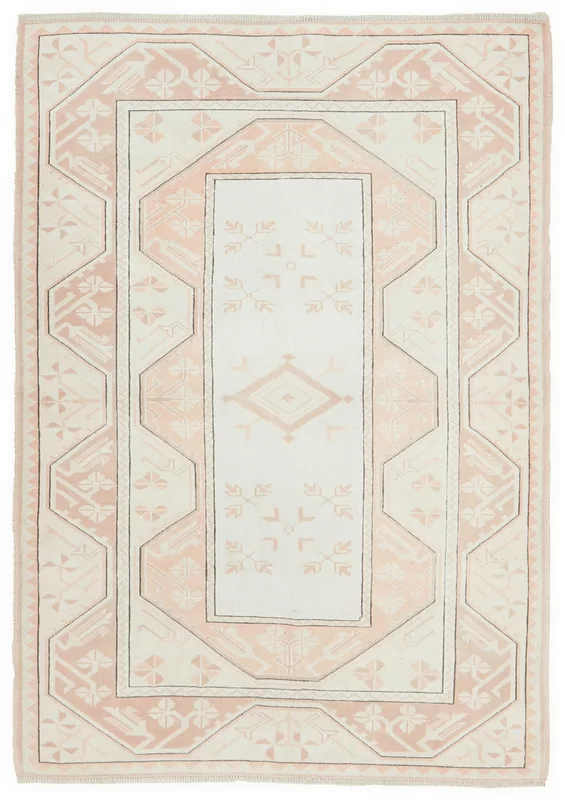 Full top view of the ivory and rose geometric Anatolian rug on a white background.