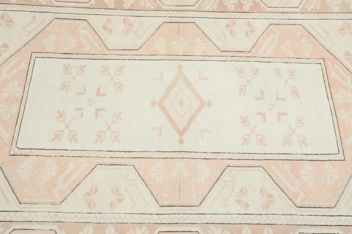 Close detail of the rug's central medallion and surrounding floral-like geometric motifs.