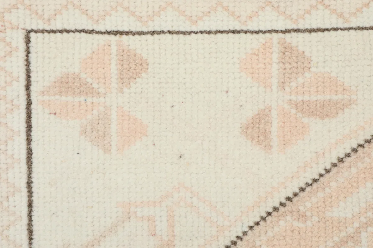 Macro view of the rug's low wool pile, showing knot texture and subtle color blending.