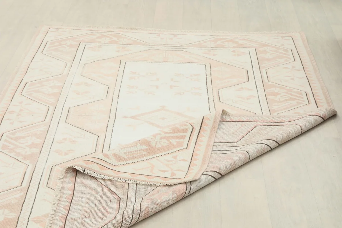 The rug partially folded, showing the flexibility and thickness of the hand-knotted construction.
