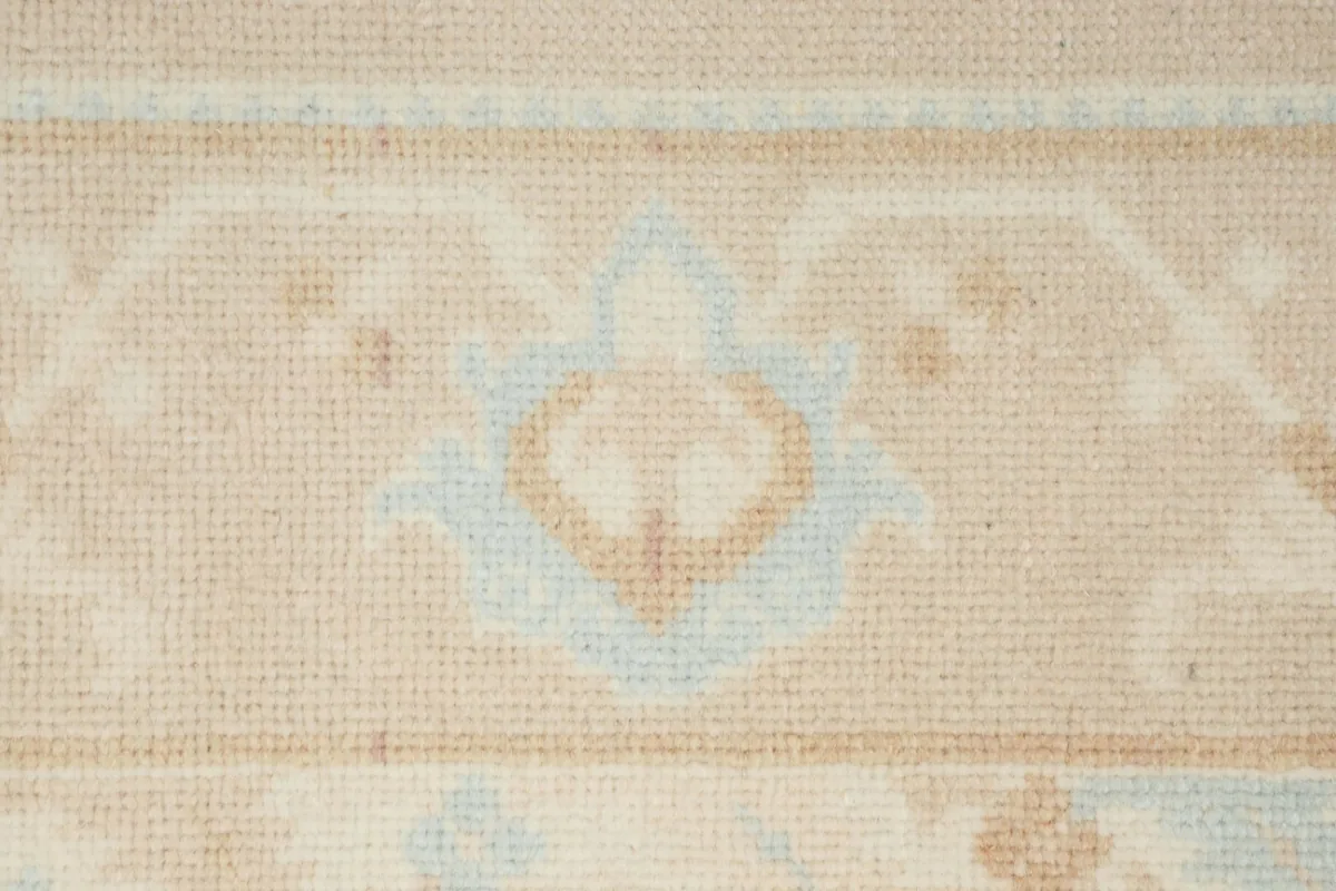 Close-up of a floral-geometric motif within the rug's border, showing wool texture.