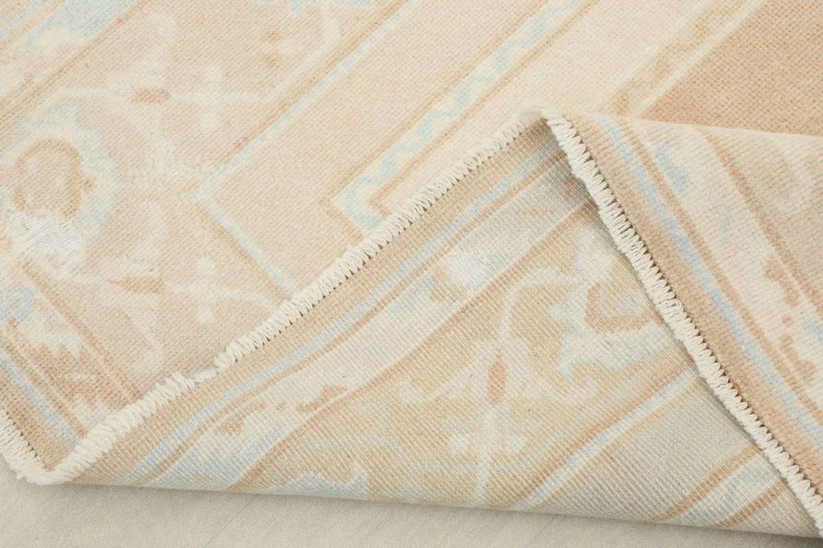 View of the rug's folded corner, revealing the cotton foundation and hand-knotted construction.