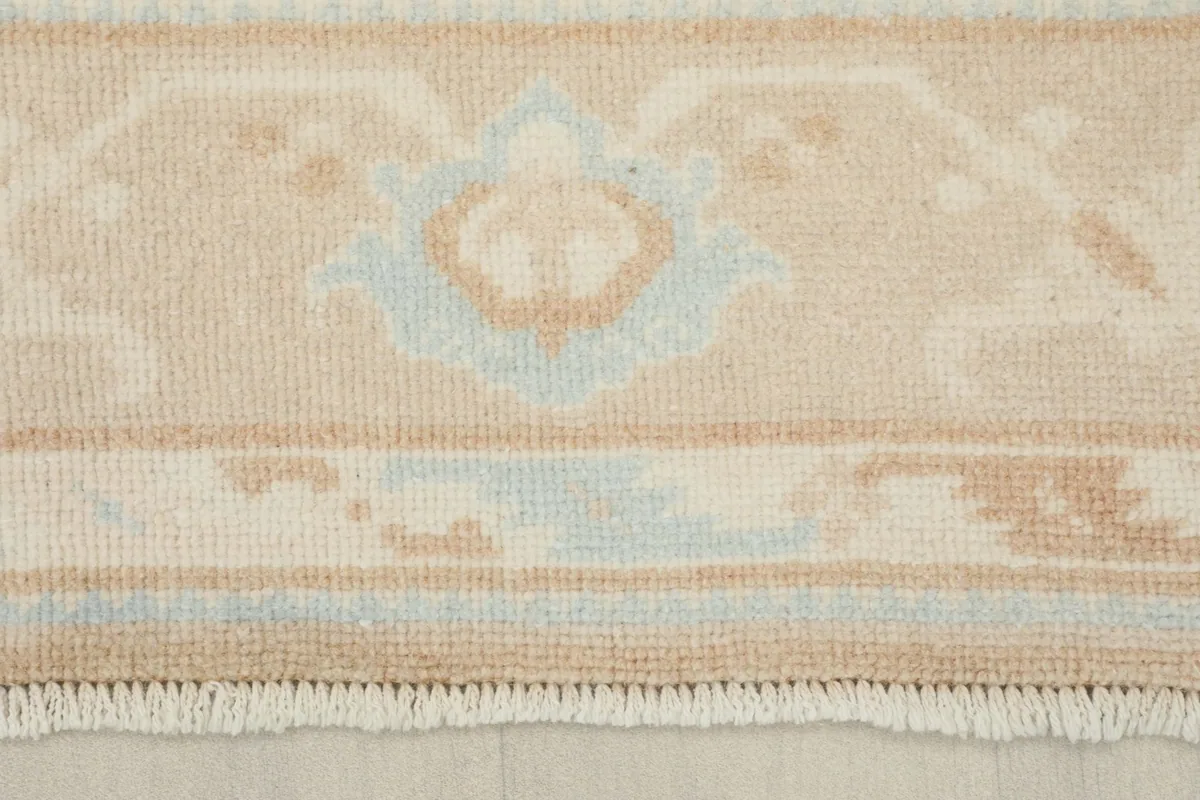 Detail of the rug's fringe and a section of the patterned border.