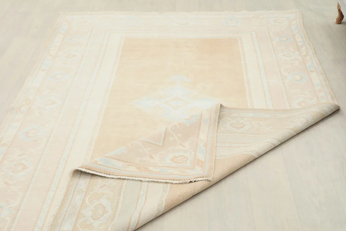 Rug partially folded, showing the flexibility and construction from the back and front.